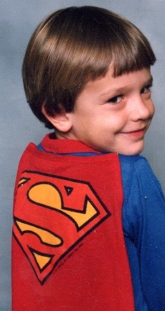 An image of a Jonathan Bailor as a child in his superman costume.